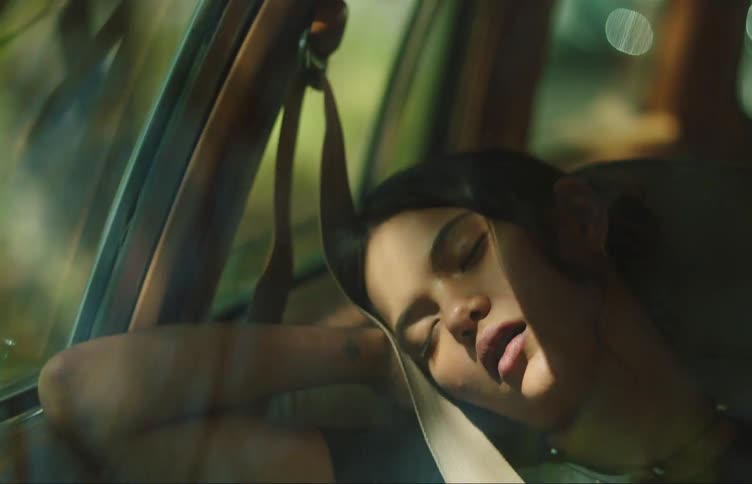 Portrait of a young woman in the passenger seat sleeping in a moving car