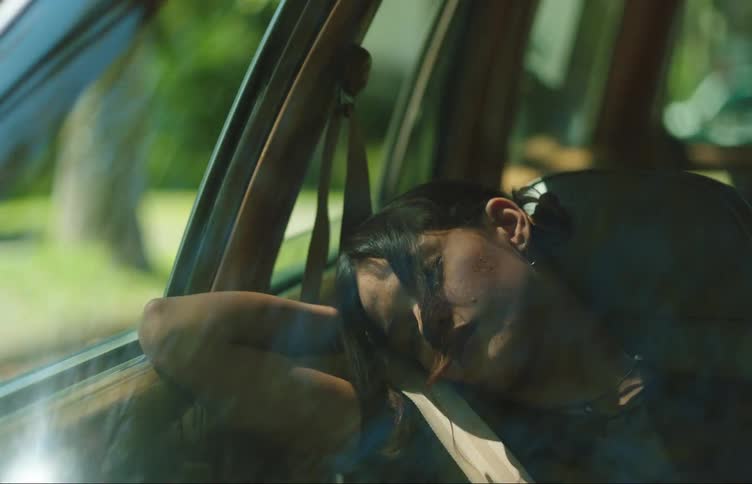 A young woman in a car sleeping in the passengers seat and not waking up even when the car breaks suddenly and her head shoots forward then back again