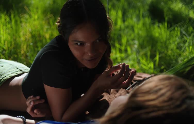Young women lying outdoors talking and smoking
