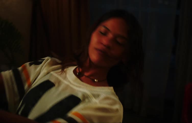 Teenage girl dancing moving her arms inside the living room at night