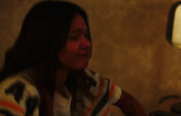 Two teenage girls dancing in a dimly lit room at home
