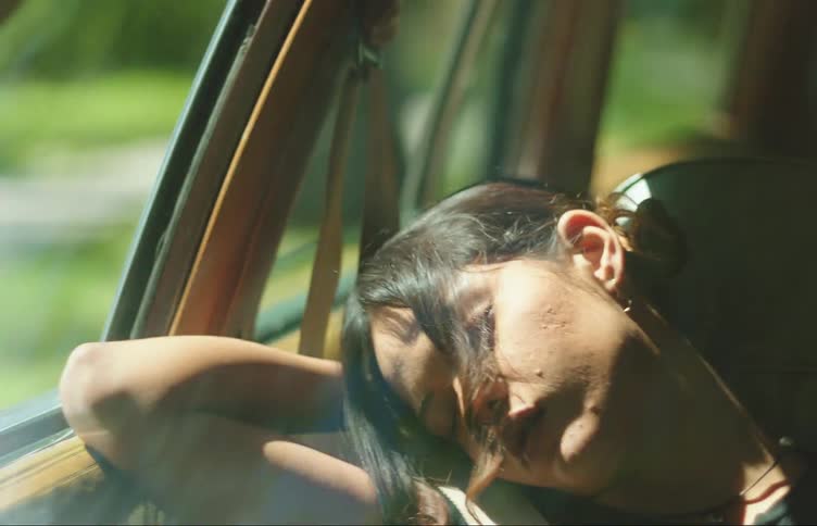 A young woman sleeping in the passenger seat of a car