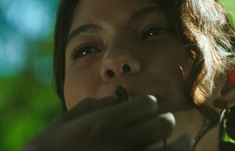 Hands of a woman handing cigarettes to another woman who begins to smoke