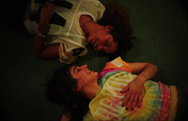 A couple of teenage girls talk on he floor of the living room