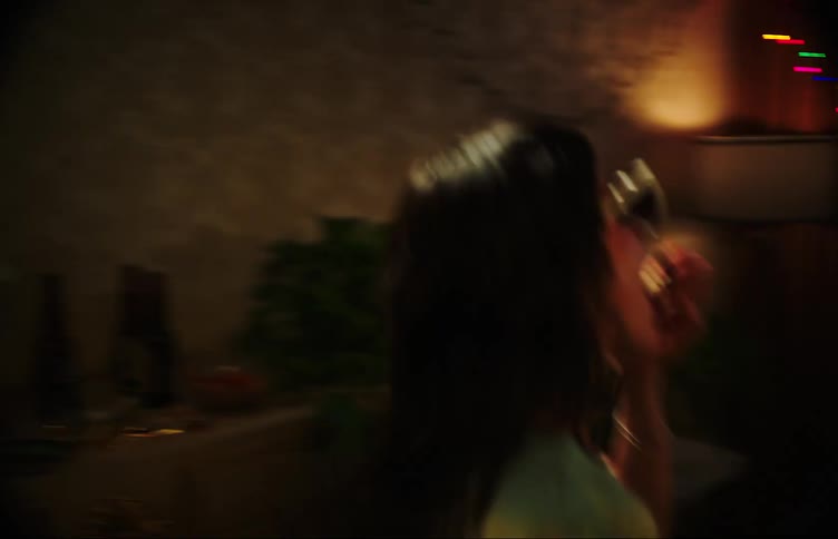 Two girls partying dancing and drinking beer with a table full of empty bottles and one of them putting on heart shaped sunglasses