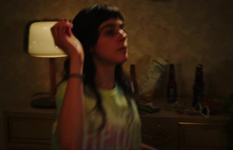 A young woman eats popcorn dancing tossing a piece at a friend