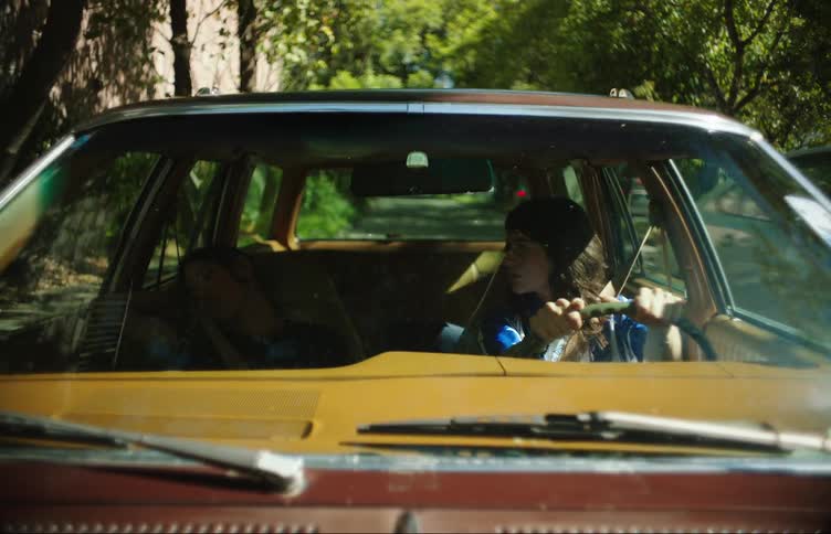 A female driving with her friend in the car
