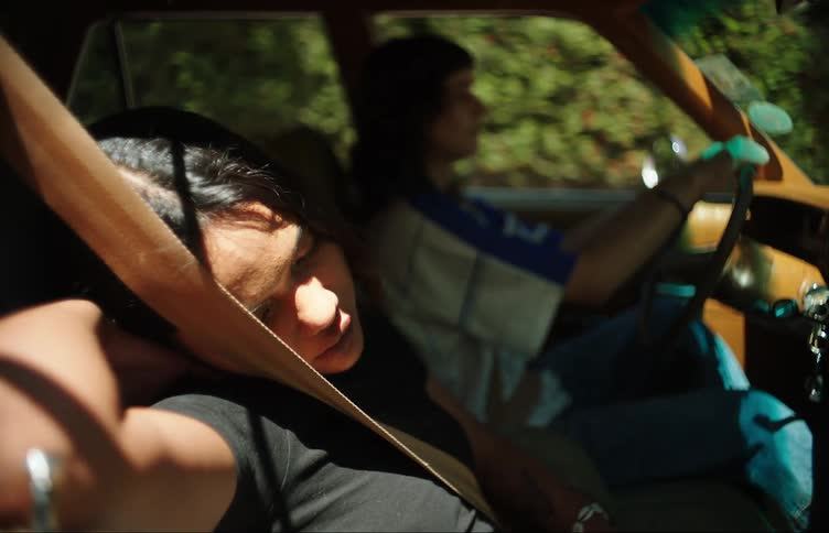 Young man and woman driving a car and next to them a girl sleeping then she brakes the vehicle suddenly and curses another driver