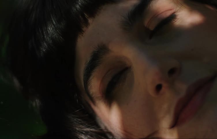 Close up of the face of a teenage girl under a tree