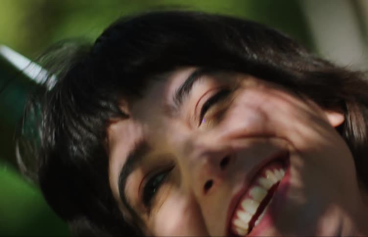 Close up of the face of a happy young woman relaxing in the backyard