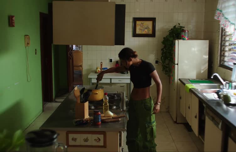 A girl patiently waits for pasta to cook in the kitchen