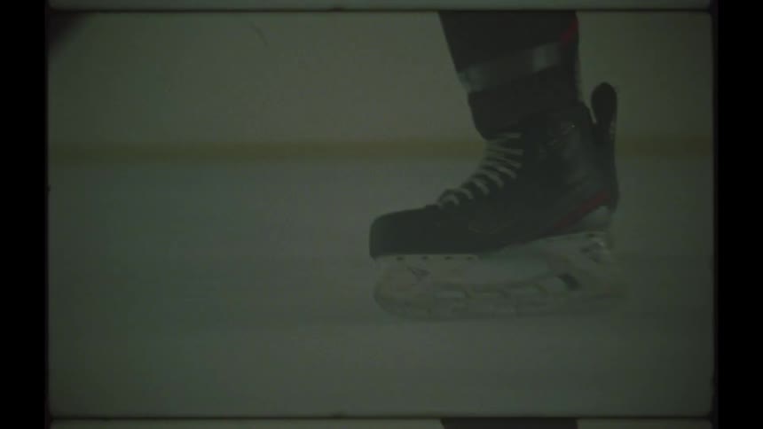 Closeup on the legs of an athlete running with a skate and on the ice playing hockey
