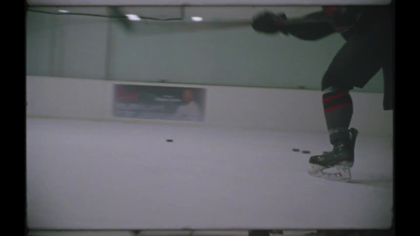 A man shooting hockey pucks into the net