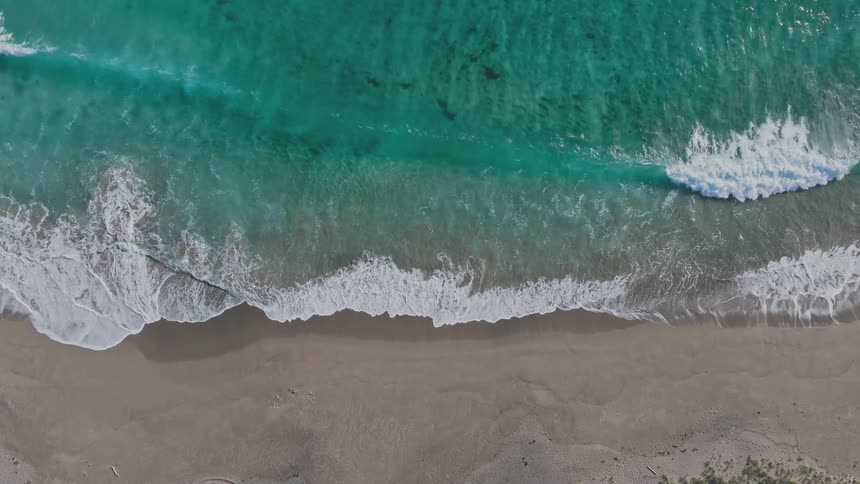 Top down aerial view of waves crashing on the beach