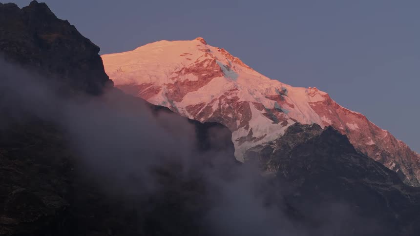 Rocky mountains with snow on a purple sky morning
