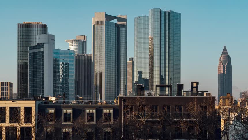 Panorama of modern skyscrapers behind urban buildings in a metropolis in time lapse in the morning
