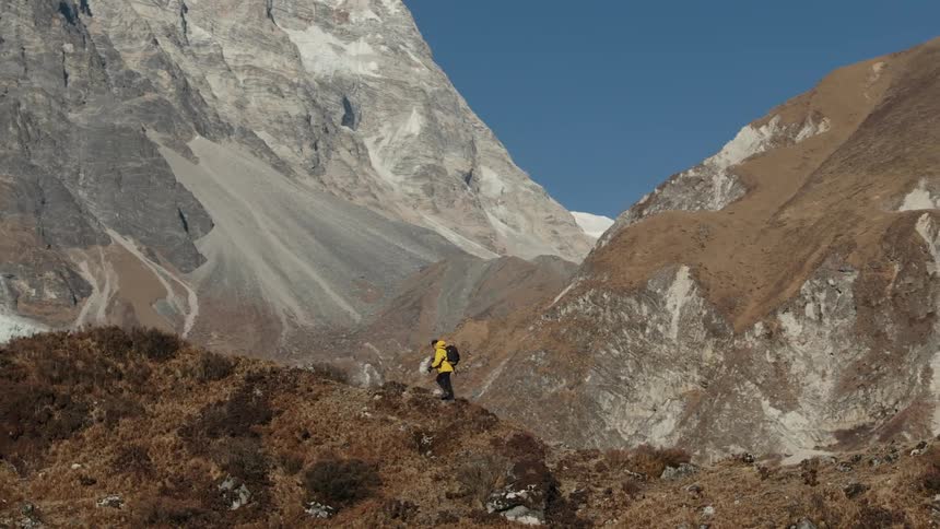 A hiker walking along the ridge on top of a mountain range