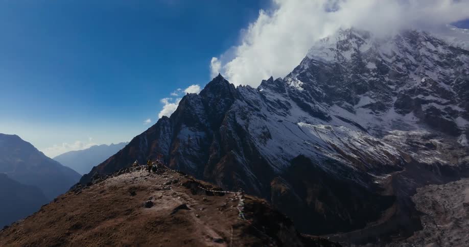 Aerial scenery of a cliff with a view of snowy mountain ranges