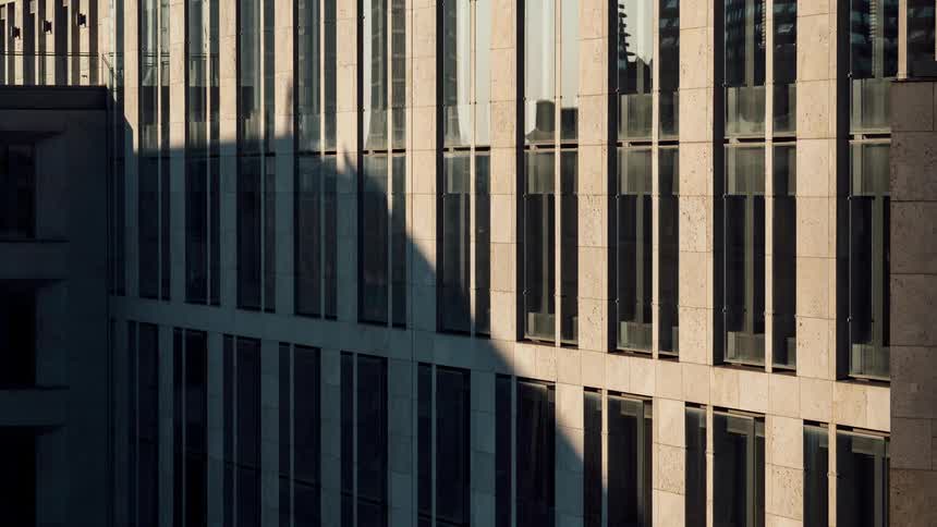 Exterior architecture of a modern mirrored building with solar reflection