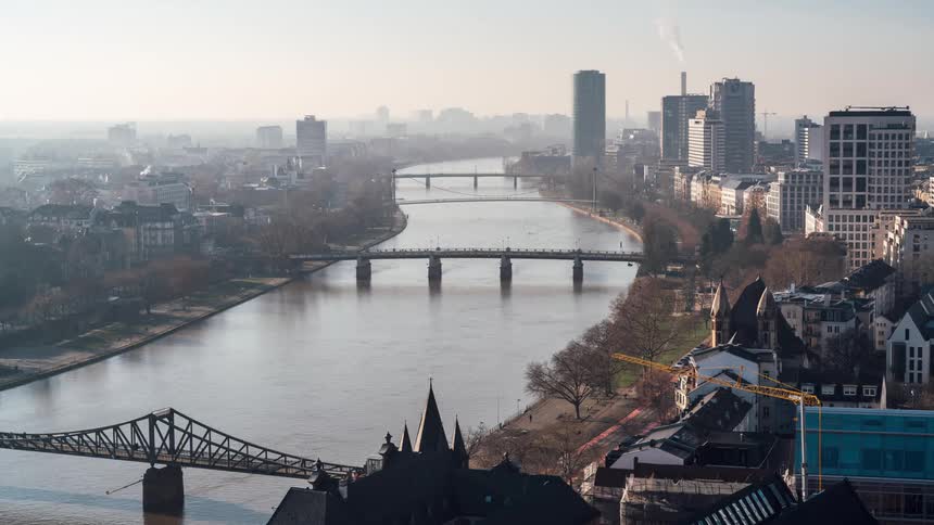 River channel with bridges connecting metropolises with factories and commercial buildings in a morning timelapse