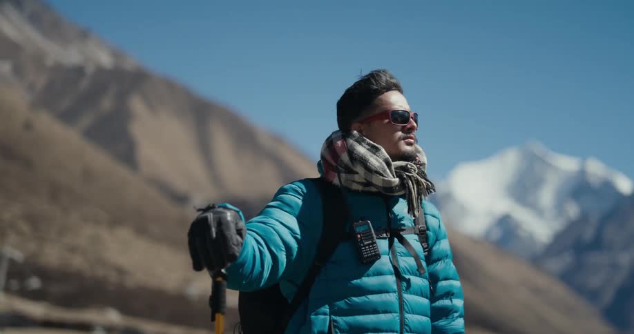 Man with hiking gear enjoying the view of mountains around him