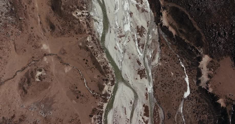 The camera follows a river flowing through a canyon