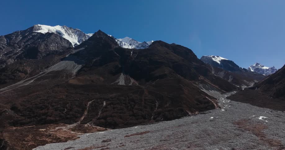 Aerial view of the barren slopes of a mountain under a blue sky