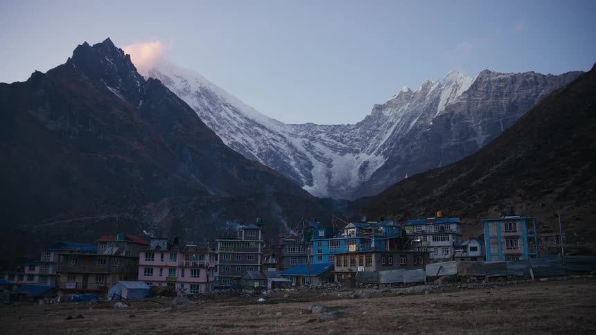 Village and plateau in a natural setting with snowy mountains all around