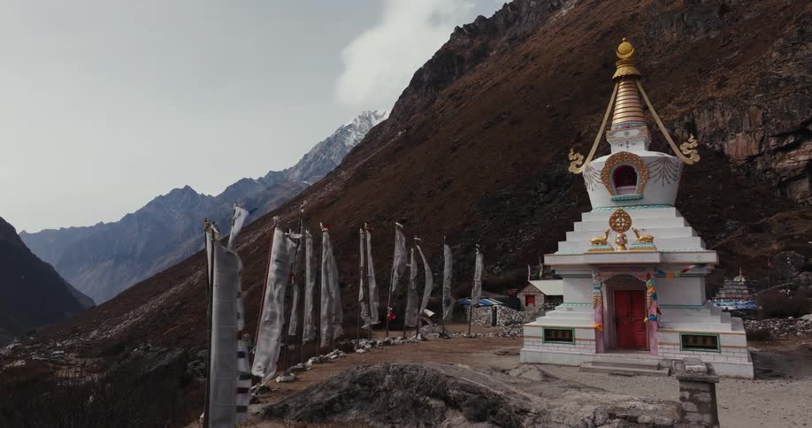 Boudhanath stupa religious temple with flags around on a hill surrounded by mountains