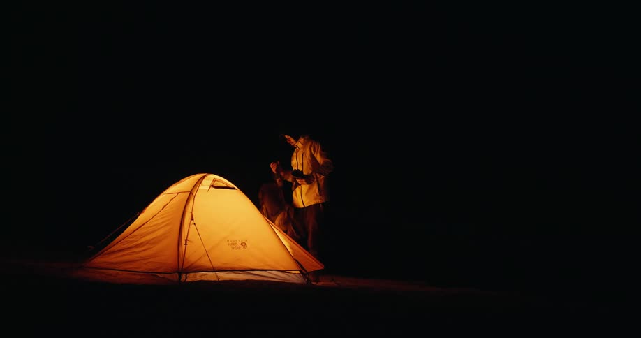 Man walks over to tent he takes off his gloves and enters it