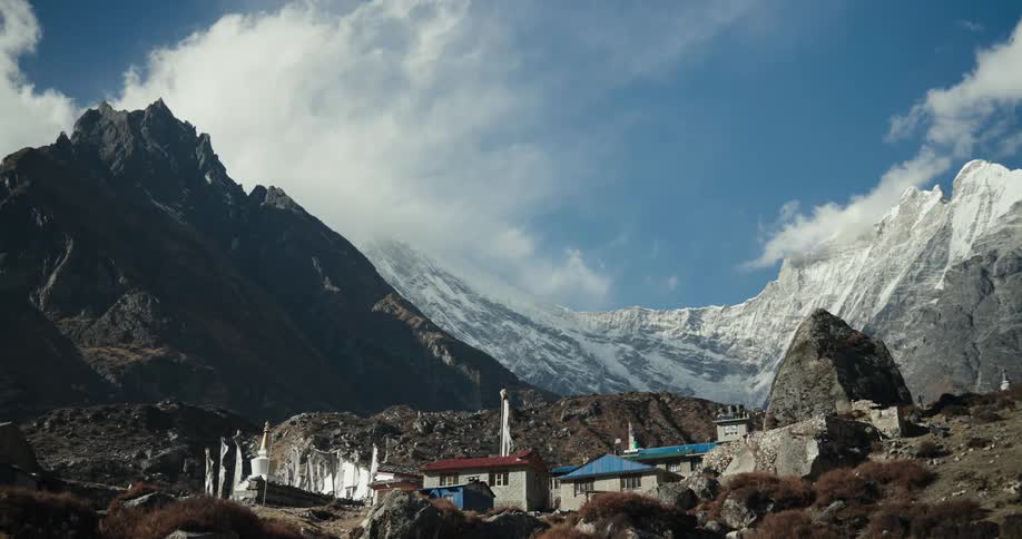 Scenery of a village on a hill surrounded by snowy mountains in winter