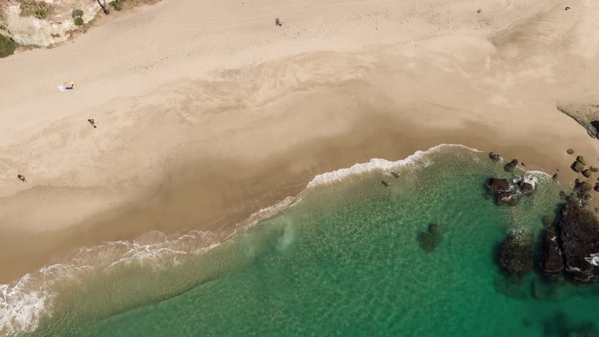 Aerial view of waves gently crashing on a beach
