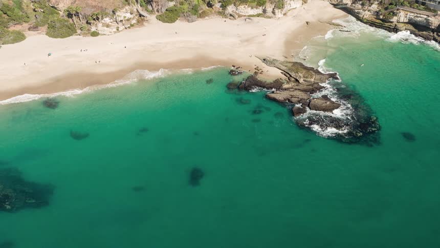 An aerial view of a coastline with waves crashing