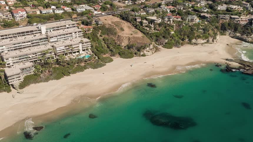 Aerial panorama of a turquoise beach with hotels and urban areas around it