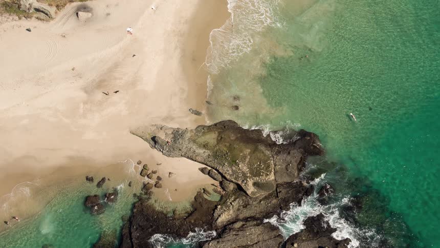Aerial view of waves gently crashing on a beach
