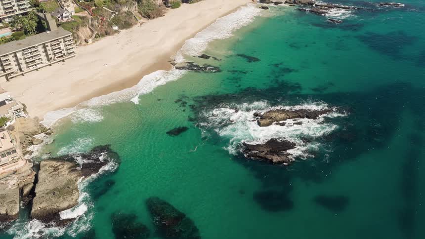 Aerial panorama of a turquoise sea at the edge of the sand and the coast with urban urban and hotel area