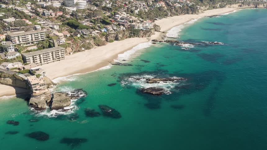 Aerial panorama of a turquoise beach on the edge of an urban city with hotel zones