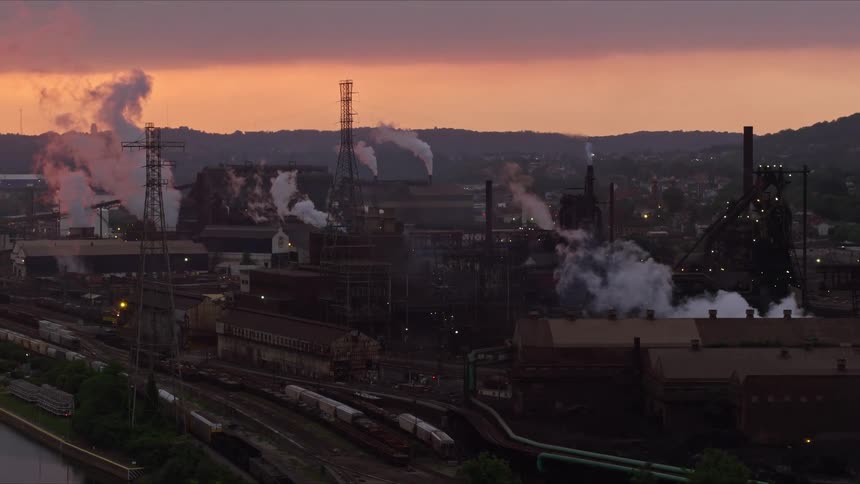 An aerial view of a steel mill at sunset