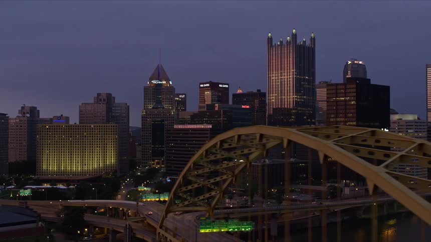 A city center with many tall buildings and a highway that is next to the water