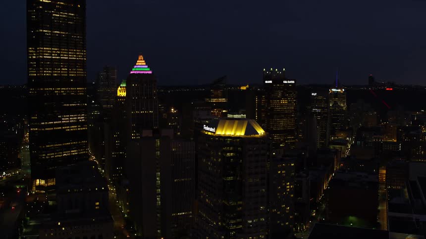 A city center with huge buildings at night and the buildings have lots of lights