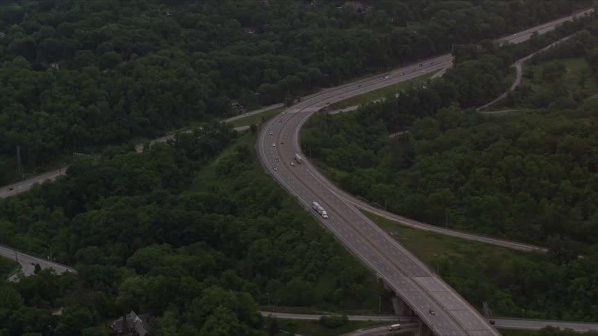 Aerial scenery of highways amidst hills with vegetation and vehicle traffic