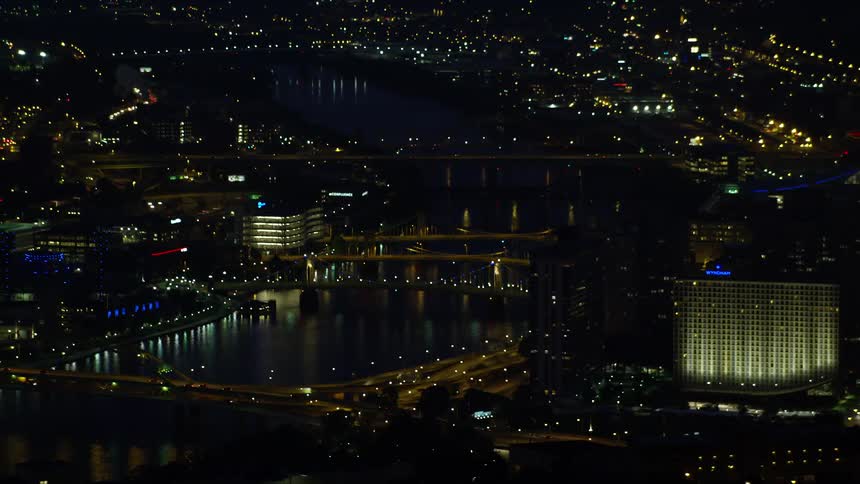 Panorama of a metropolis at night illuminated with lights on the edge of a river canal and with modern residential and commercial buildings