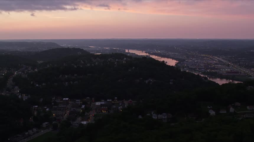 Aerial panorama of an urban city built on hills and mountains on a purple sky day