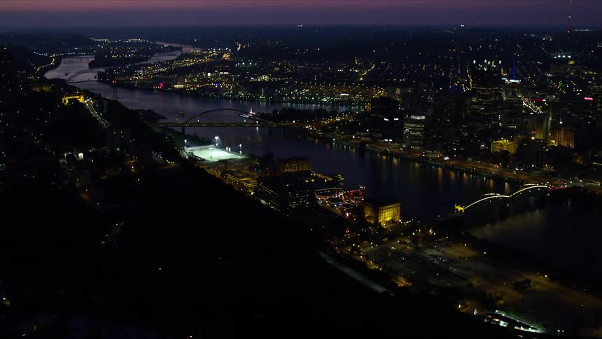 Aerial view of a city with a river at night