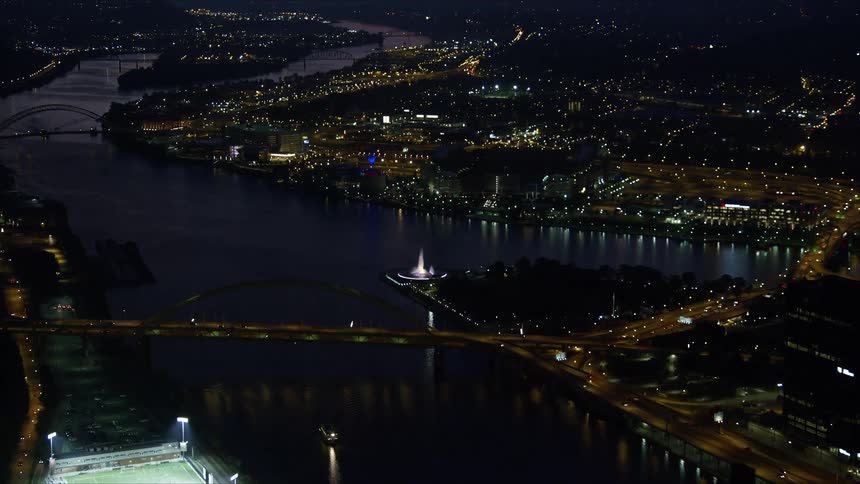 Aerial panorama of a metropolis at night illuminated with bridges over sea canals