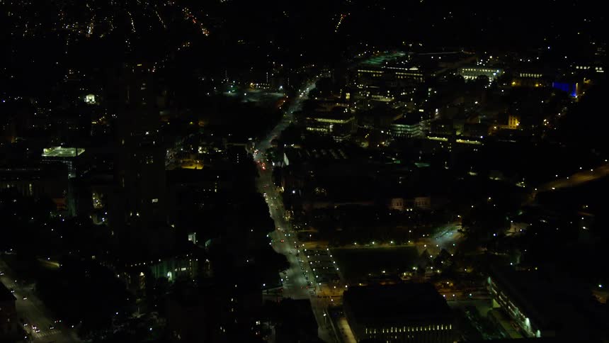 An aerial view of a city at night with many residential and connected lights