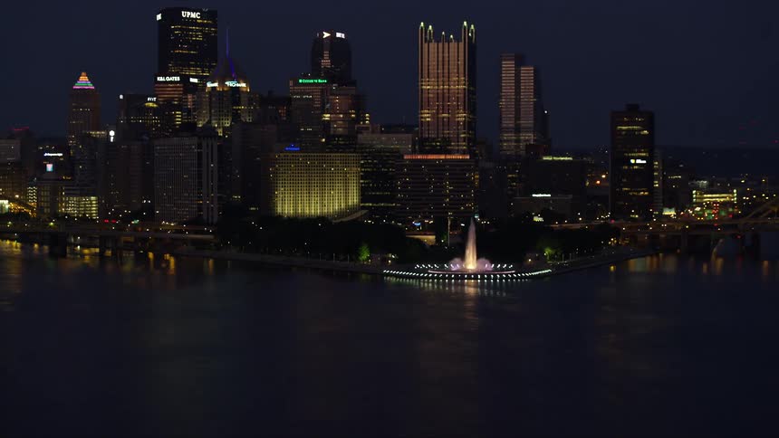 Panorama of a modern metropolis with commercial and urban skyscraper buildings on the seafront with an interconnecting bridge at night