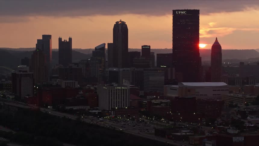 Panorama of a metropolis with skyscrapers by the sea and the sunset on the horizon