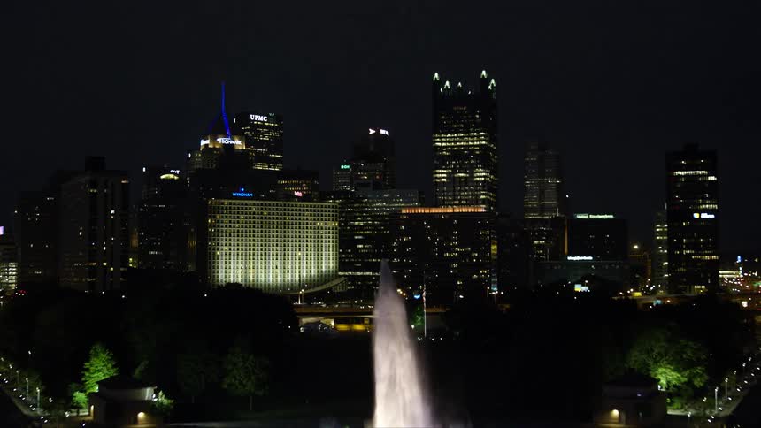 Panorama at night of a metropolis with large illuminated modern buildings on the seafront