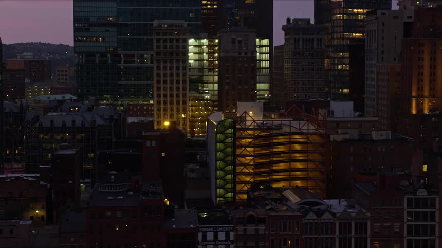 Panorama of a metropolis with modern cell buildings and skyscrapers illuminated at night with purple sky